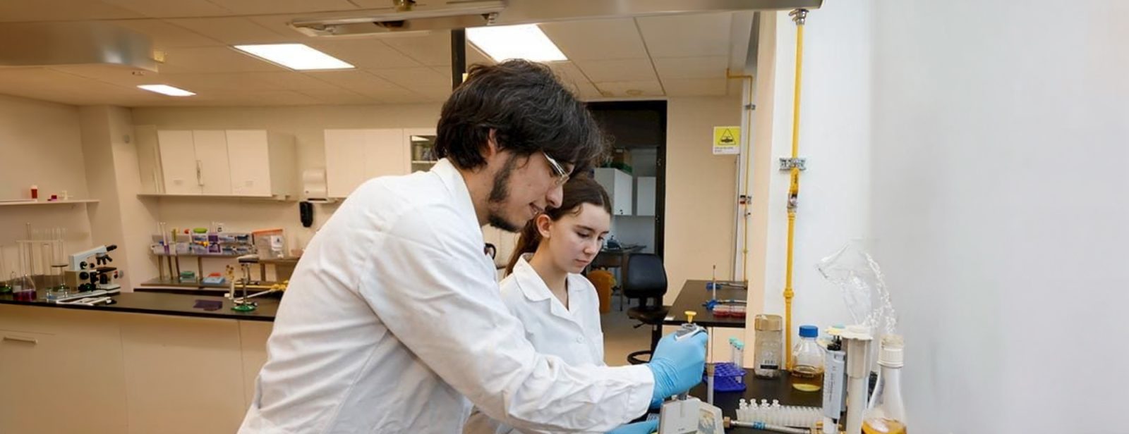 dos investigadores trabajando en un laboratorio con equipo científico